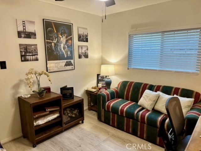 living room featuring light hardwood / wood-style floors and ceiling fan