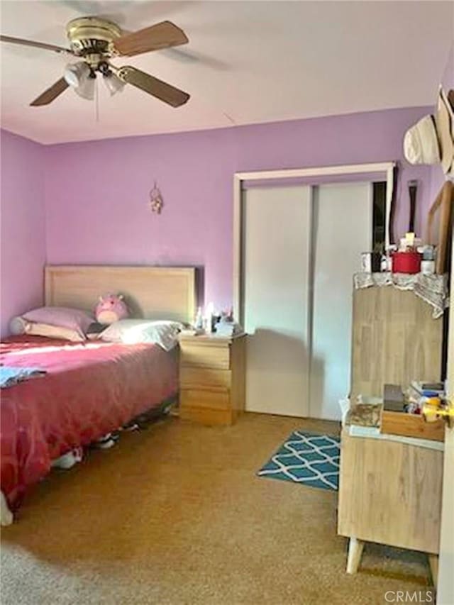 carpeted bedroom with ceiling fan and a closet