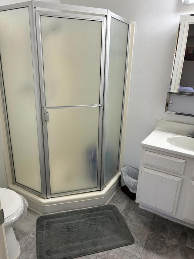 bathroom with vanity, toilet, and an enclosed shower