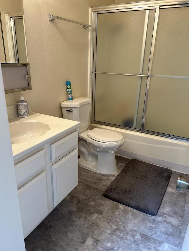 full bathroom featuring enclosed tub / shower combo, vanity, and toilet