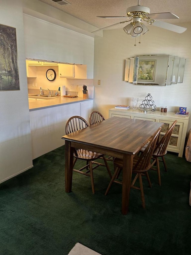 dining area with dark carpet, a textured ceiling, sink, and ceiling fan