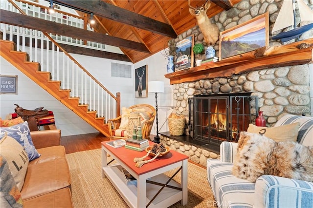 living room featuring wooden ceiling, vaulted ceiling with beams, a fireplace, and hardwood / wood-style floors