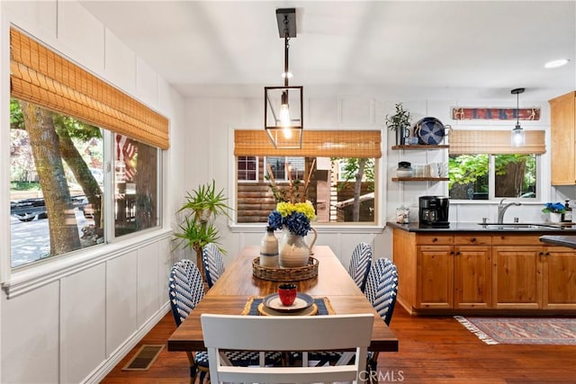 dining space with a healthy amount of sunlight, dark hardwood / wood-style floors, and sink