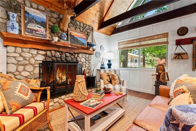 sitting room with wood-type flooring, vaulted ceiling with beams, a fireplace, wood walls, and wooden ceiling