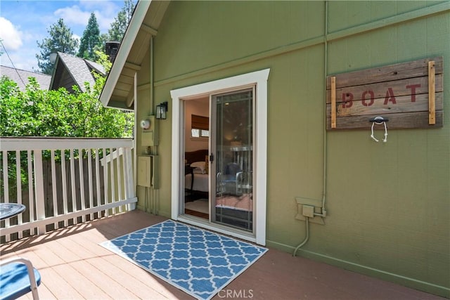 view of exterior entry featuring a wooden deck