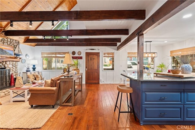 living room featuring hardwood / wood-style flooring, wooden ceiling, beam ceiling, and a fireplace