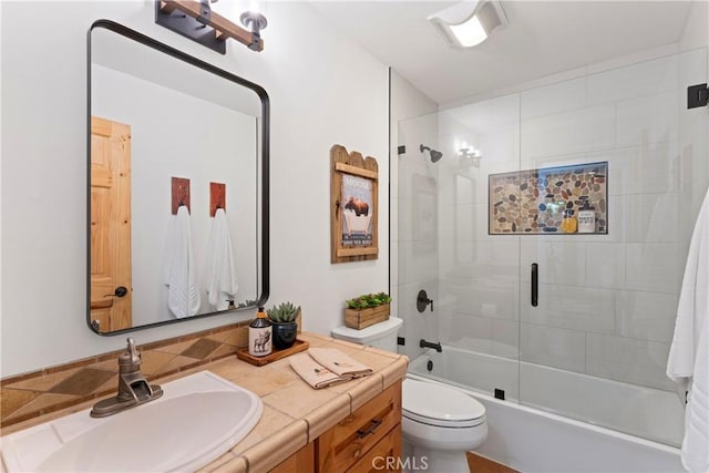 full bathroom with toilet, enclosed tub / shower combo, and vanity