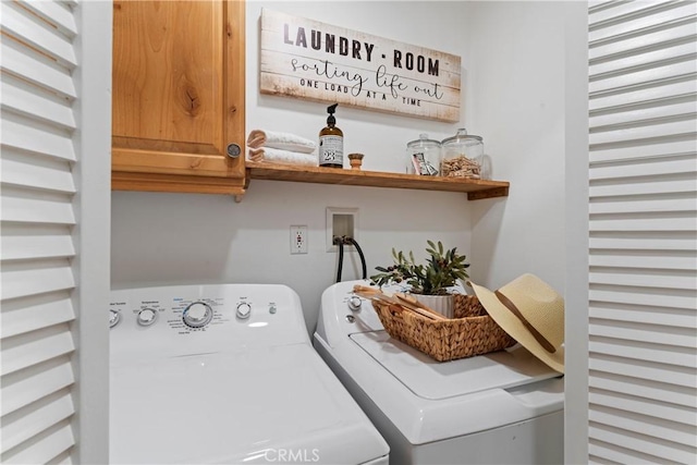 laundry room featuring washer and dryer and cabinets