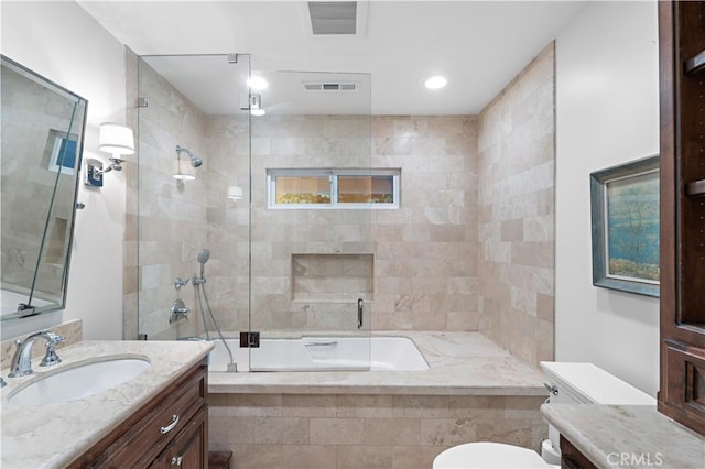 full bathroom featuring tiled shower / bath, visible vents, vanity, and toilet