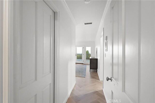 hall with ornamental molding and light parquet flooring