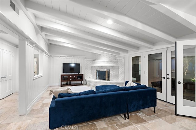 living area featuring stone tile floors, a fireplace, and visible vents