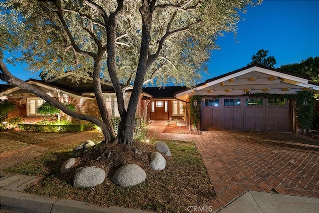 ranch-style home with decorative driveway and an attached garage