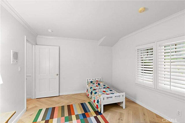 bedroom with crown molding and light parquet floors