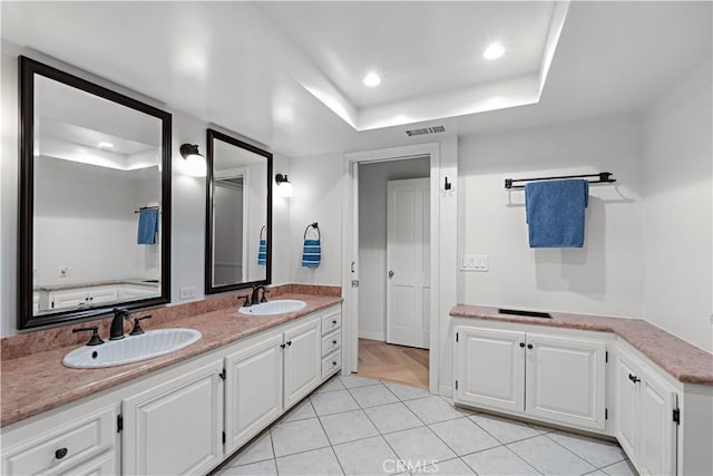 bathroom with a raised ceiling, vanity, and tile patterned floors