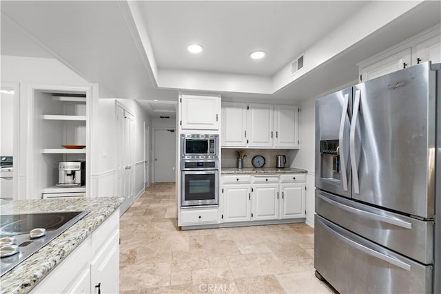 kitchen featuring built in shelves, visible vents, white cabinetry, appliances with stainless steel finishes, and light stone countertops