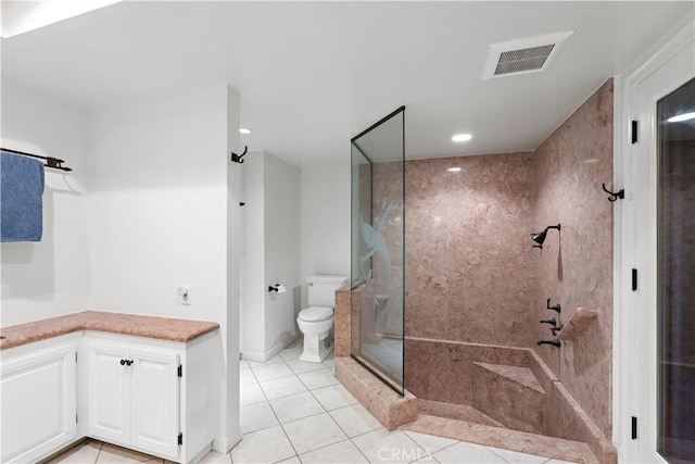 full bathroom featuring tile patterned flooring, toilet, vanity, visible vents, and a stall shower