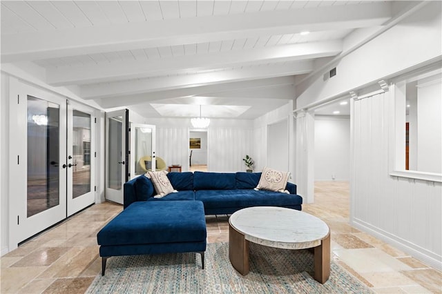 living room with french doors, visible vents, beamed ceiling, and stone tile floors