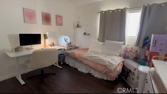 bedroom with dark wood-type flooring