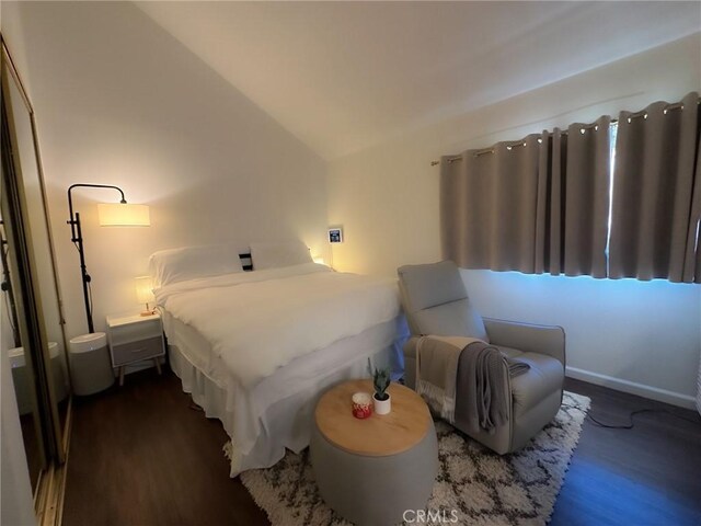 bedroom featuring vaulted ceiling and dark wood-type flooring