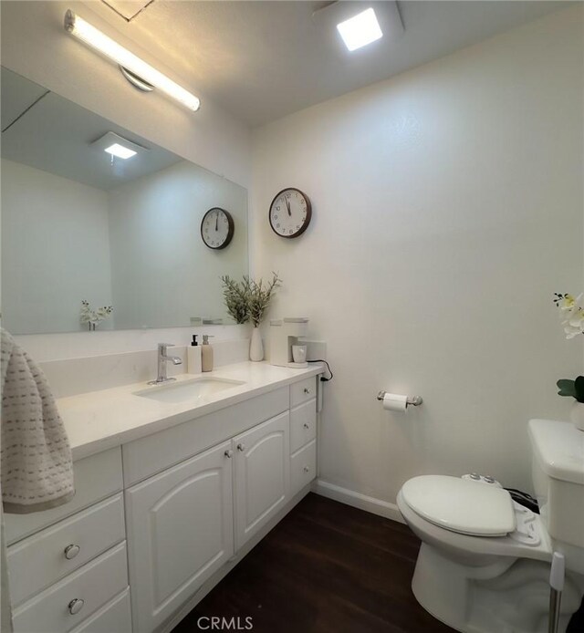 bathroom featuring vanity, wood-type flooring, and toilet