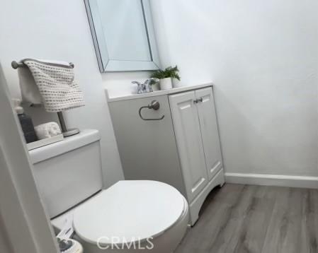 bathroom featuring vanity, toilet, and wood-type flooring