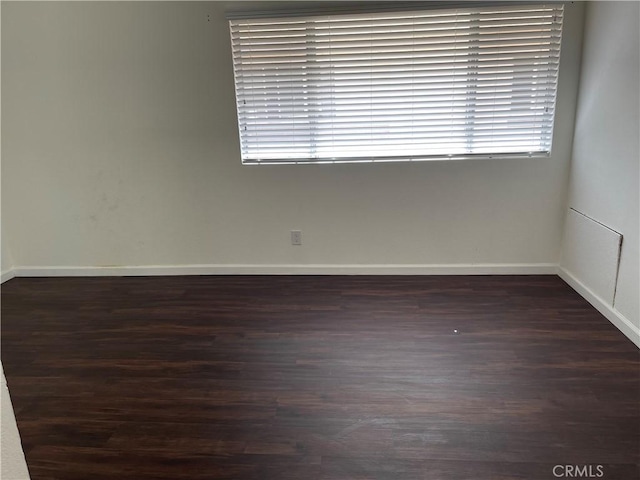 spare room featuring dark wood-type flooring