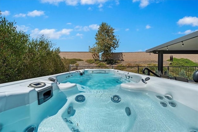 view of swimming pool with a hot tub