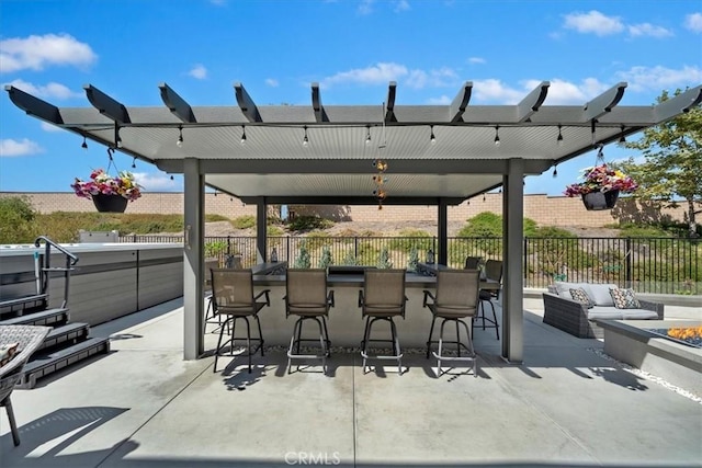 view of patio / terrace with outdoor lounge area, exterior bar, and a hot tub