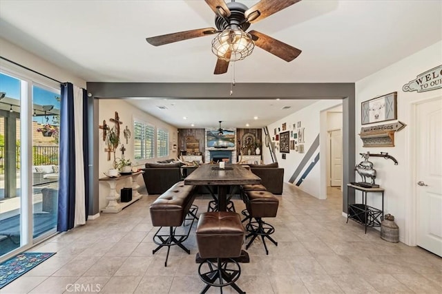 tiled dining area featuring a fireplace, plenty of natural light, and ceiling fan