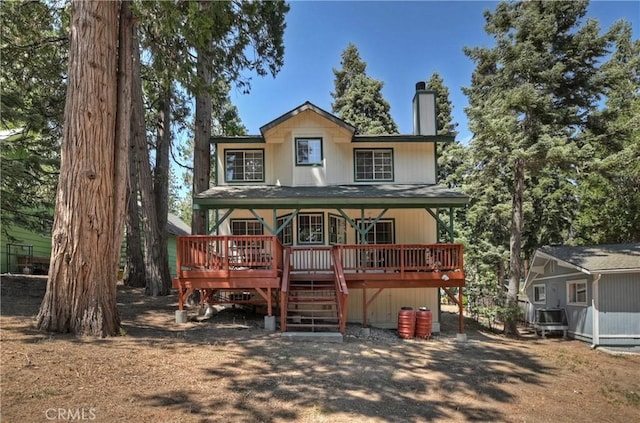 rear view of property featuring central AC unit and a wooden deck