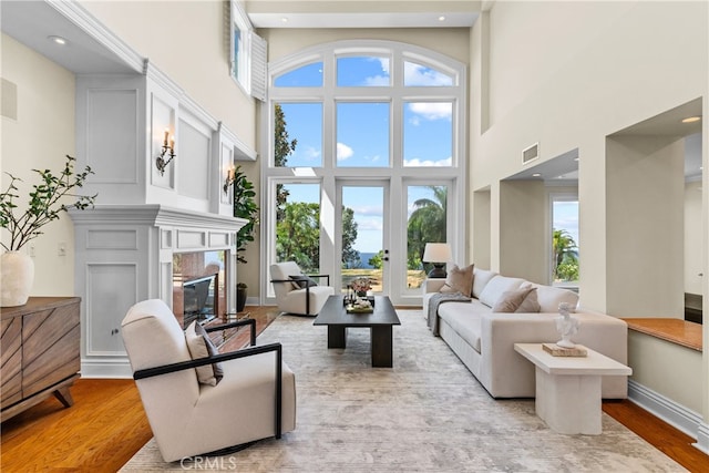 living room featuring light hardwood / wood-style floors and a towering ceiling