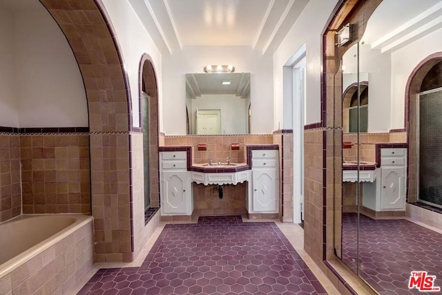 bathroom with tile patterned flooring, vanity, separate shower and tub, and tile walls