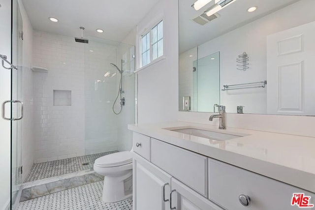 bathroom featuring vanity, toilet, and a shower with door