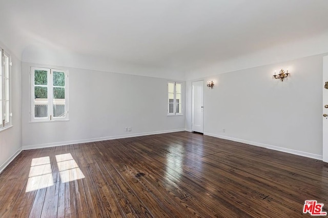 spare room featuring a wealth of natural light and dark hardwood / wood-style flooring