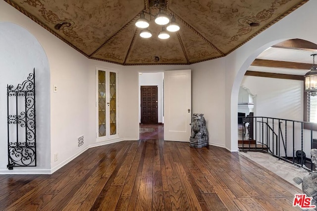 unfurnished room with lofted ceiling with beams, dark hardwood / wood-style flooring, and built in shelves