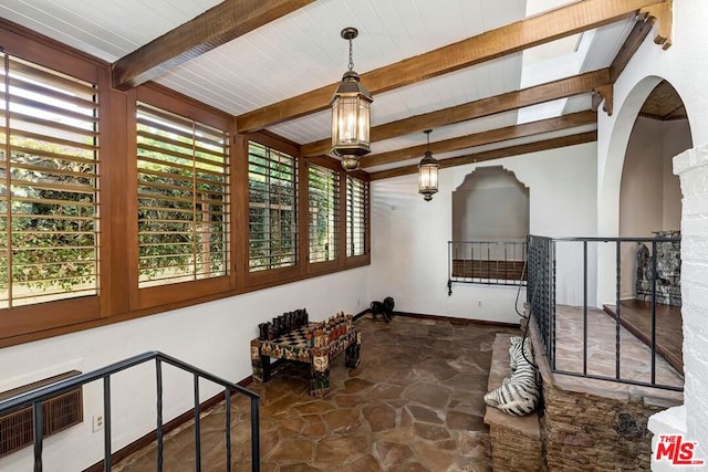 interior space featuring beam ceiling, a wealth of natural light, and wood ceiling