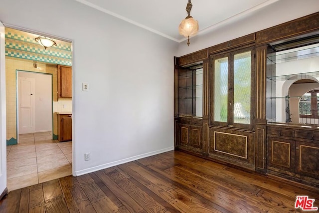 empty room featuring french doors, crown molding, and dark wood-type flooring