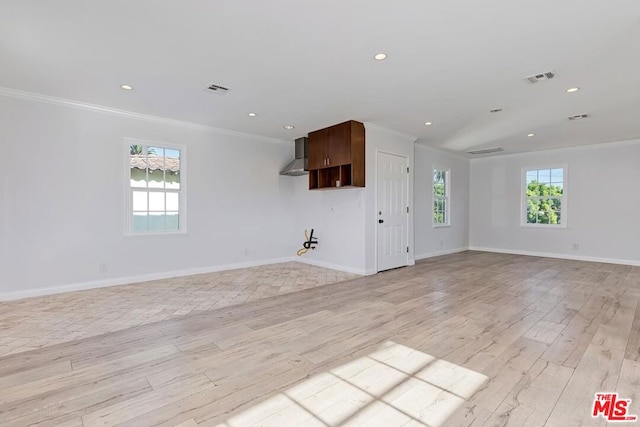 unfurnished living room featuring light wood-type flooring, crown molding, and a wealth of natural light