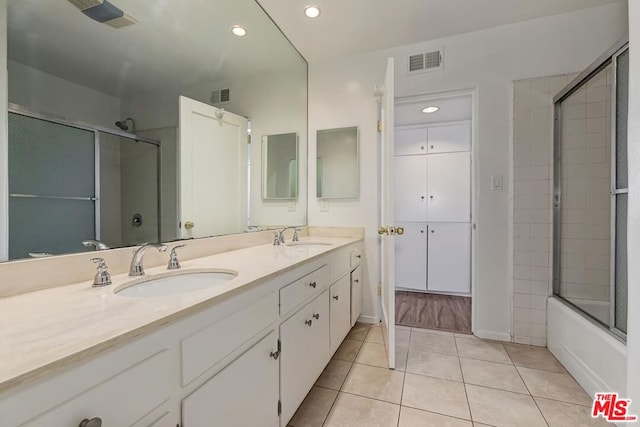 bathroom with tile patterned flooring, vanity, and combined bath / shower with glass door