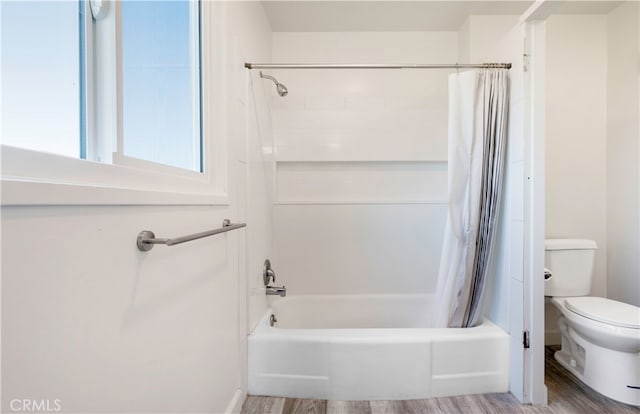 bathroom with shower / bath combination with curtain, hardwood / wood-style flooring, and toilet