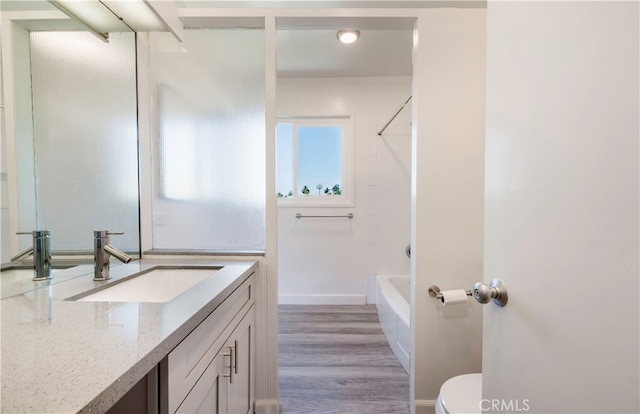 full bathroom with shower / bathtub combination, vanity, toilet, and hardwood / wood-style flooring