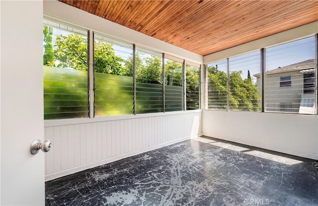 unfurnished sunroom featuring wood ceiling and a wealth of natural light