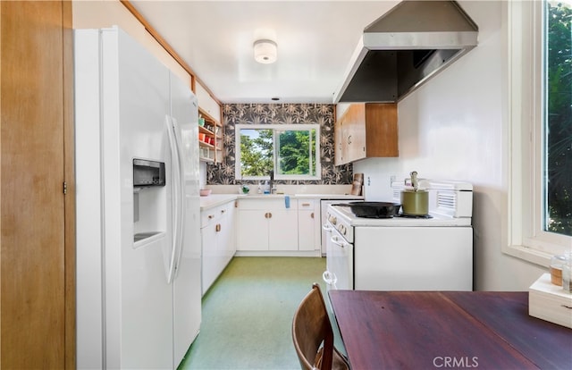 kitchen featuring white appliances, white cabinetry, exhaust hood, and sink