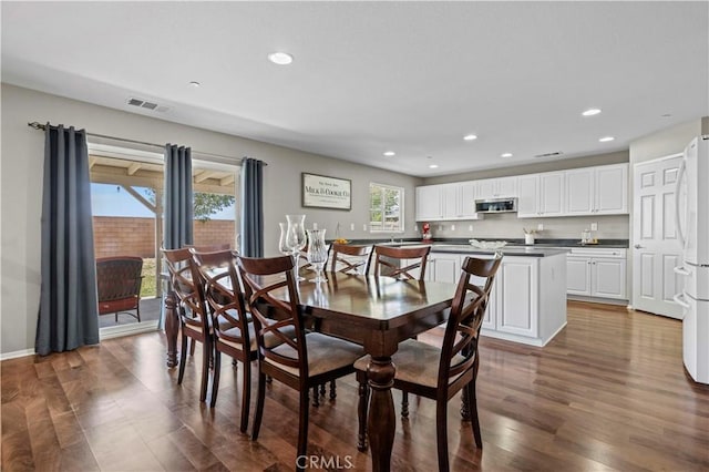 dining room featuring a healthy amount of sunlight and dark wood-type flooring