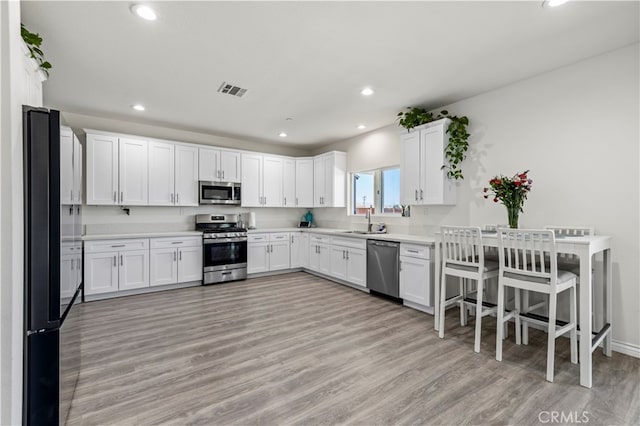 kitchen featuring appliances with stainless steel finishes, white cabinetry, and sink