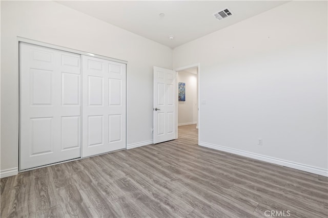 unfurnished bedroom with light hardwood / wood-style flooring and a closet