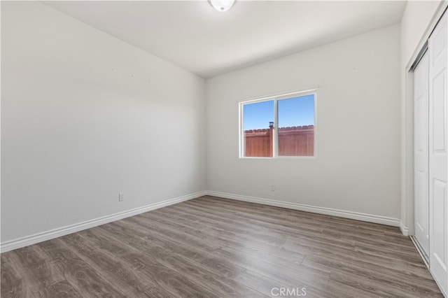 unfurnished bedroom with a closet and hardwood / wood-style floors