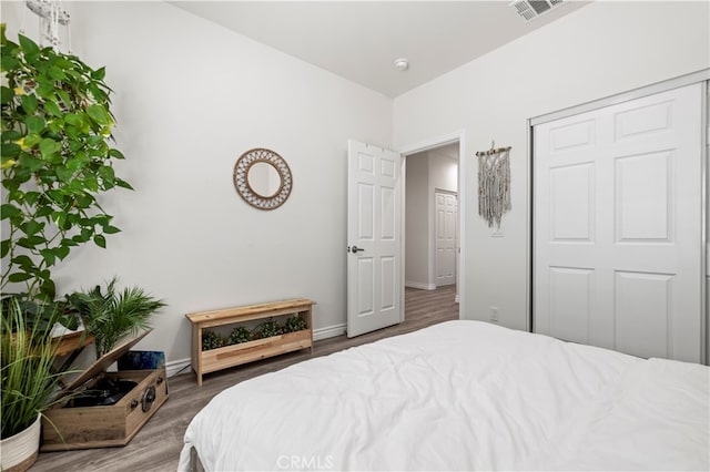 bedroom with a closet and dark hardwood / wood-style flooring