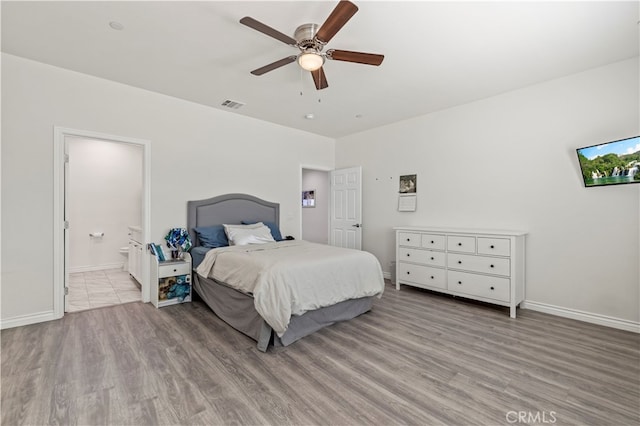 bedroom featuring light hardwood / wood-style floors, ensuite bath, and ceiling fan