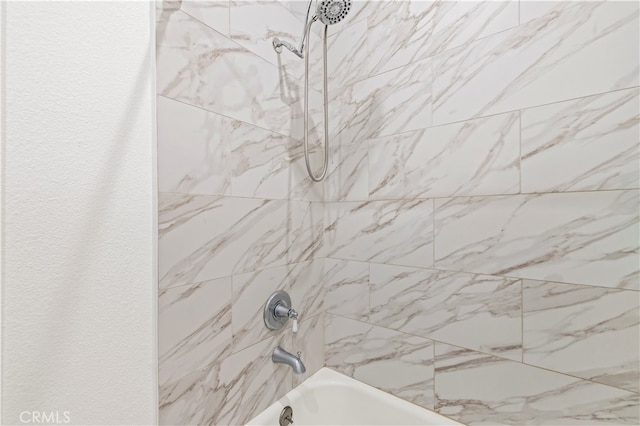 room details with tiled shower / bath combo